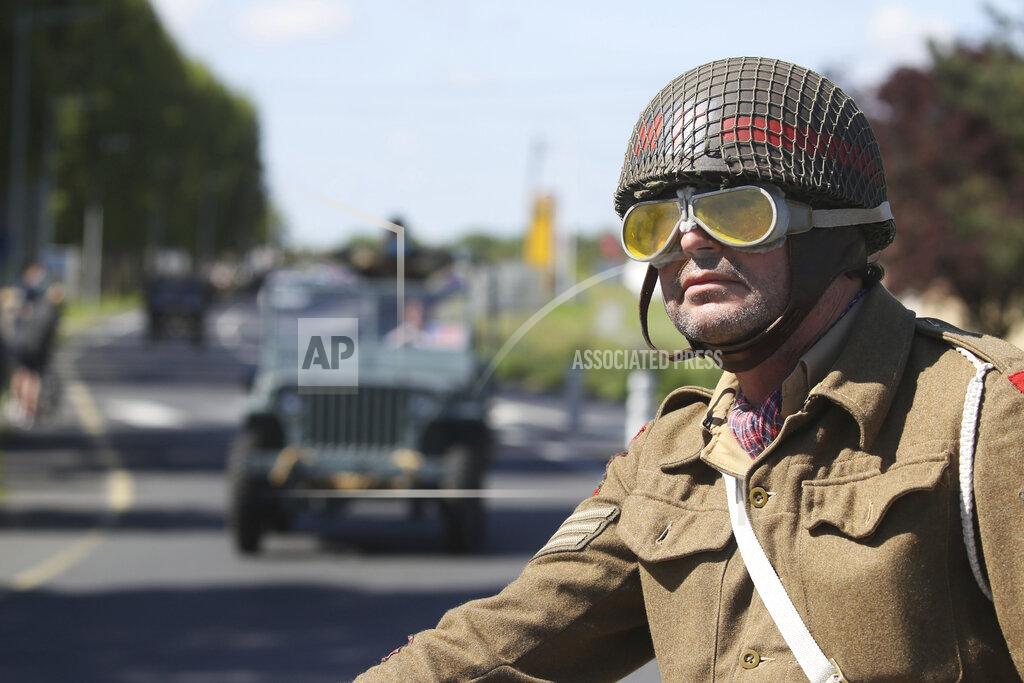 David Vincent World War II history enthusiasts parade in WWII vehicles in Ouistreham, Normandy, Saturday June, 5 2021 on the eve of 77th anniversary of the assault that helped bring an end to World War II. While France is planning to open up to vaccinated visitors starting next week, that comes too late for the D-Day anniversary. So for the second year in a row, most public commemoration events have been cancelled. A few solemn ceremonies have been maintained, in the presence of dignitaries and a few guests only. (AP Photo/David Vincent)