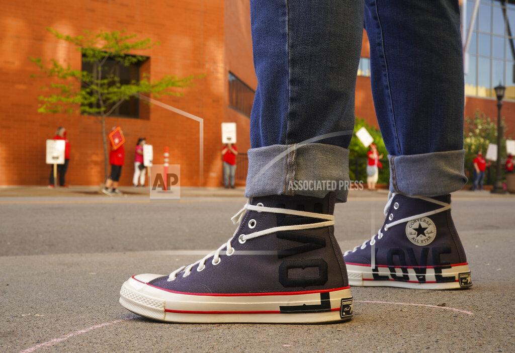 Jeff Wheeler Kym Maginn, a registered nurse at North Memorial, wears sneakers with a message, Wednesday, May 20, 2020, in St. Paul, Minn., during an informational picket sponsored by the Minnesota Nurses Association along Smith Avenue, outside United Hospital. Nurses are asking for a say in worker protections, increased PPE resources with higher safety standards and an end to retaliation against workers who have tried to protect themselves from the COVID-19 virus. After picketing, they marched to the State Capitol to hear speakers. (Jeff Wheeler/Star Tribune via AP)
