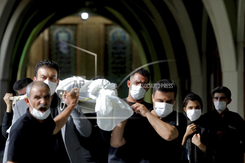 Ebrahim Noroozi Mourners carry the body of a person who died from COVID-19 at the Behesht-e-Zahra cemetery on the outskirts of Tehran, Iran, Sunday, Nov. 1, 2020. The cemetery is struggling to keep up with the coronavirus pandemic ravaging Iran, with double the usual number of bodies arriving each day and grave diggers excavating thousands of new plots. (AP Photo/Ebrahim Noroozi)