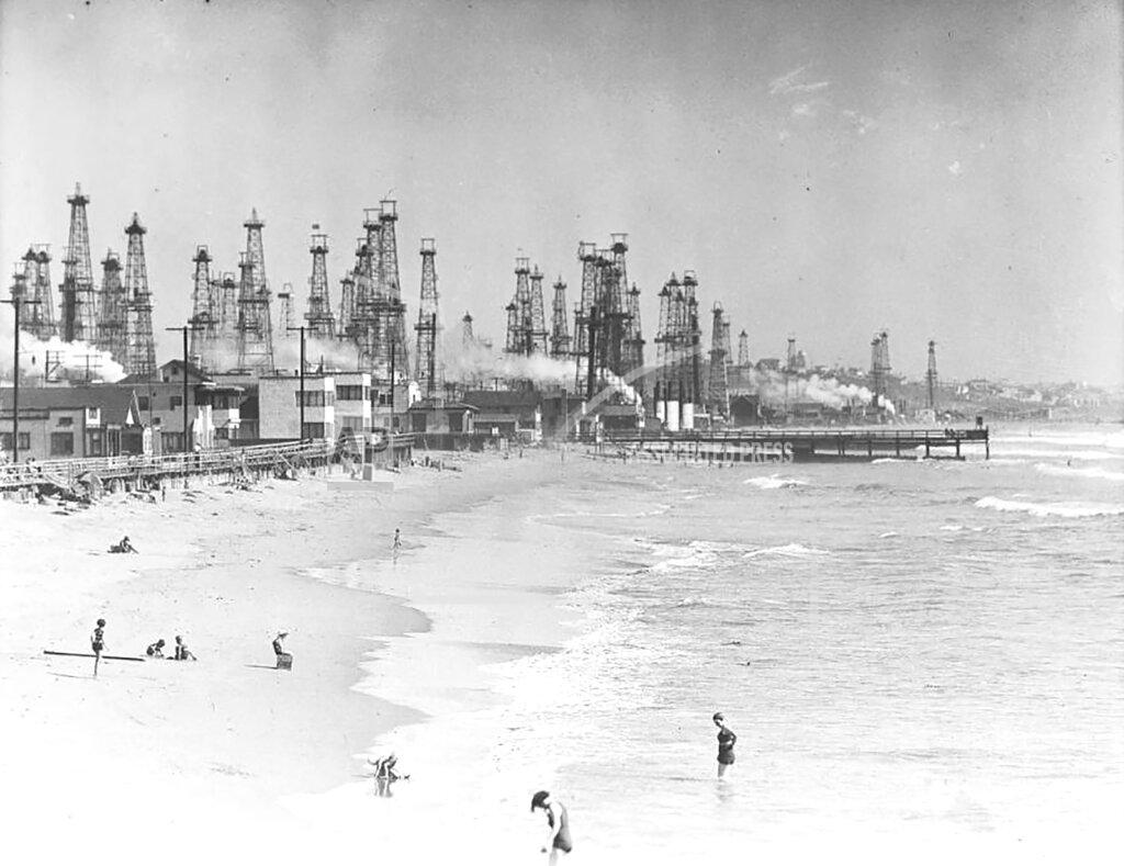 Uncredited In this undated historical image provided by the University of Southern California library, people enjoy the beach in front of an oil field in Playa del Rey, Calif. There are 3.2 million abandoned oil and gas wells in the U.S., according to the Environmental Protection Agency. About a third were plugged with cement, which is considered the proper way to prevent harmful chemical leaks. But most, about 2.1 million by the EPA's count, haven't been plugged at all. (USC via AP)