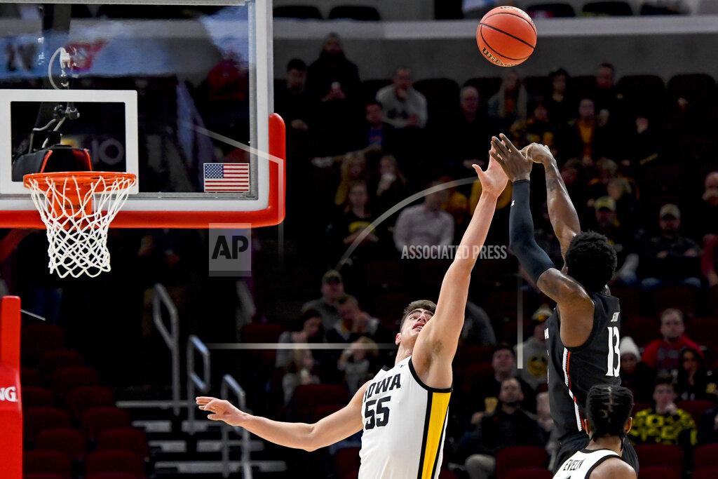 Matt Marton Iowa center Luka Garza (55) defends against a shot by Cincinnati forward Tre Scott (13) during the first half of an NCAA college basketball game Saturday, Dec. 21, 2019, in Chicago. (AP Photo/Matt Marton)
