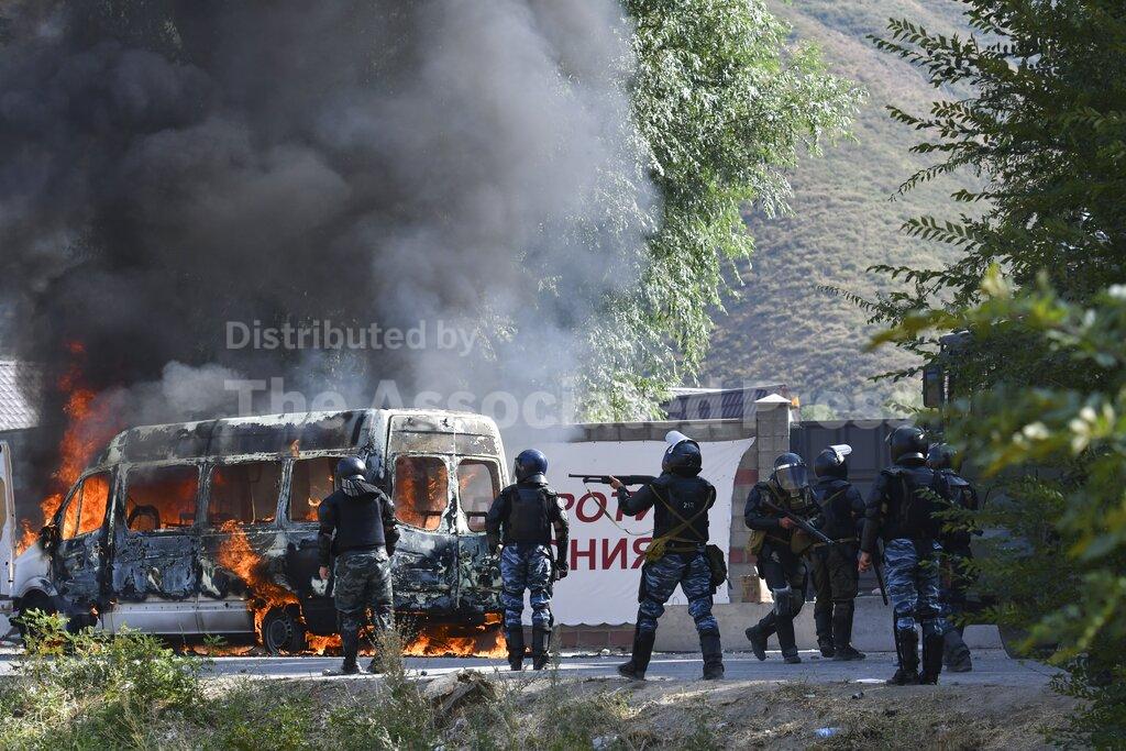 Kyrgyz riot police shoot rubber bullets to stop supporters of former president Almazbek Atambayev, near his residence in the village of Koi-Tash, about 20 kilometers (12 miles) south of the capital, Bishkek, Kyrgyzstan, Thursday, Aug. 8, 2019. Police in Kyrgyzstan detained the Central Asian nation's ex-president Thursday following violent clashes with his supporters, a day after a previous attempt to arrest him left one policeman dead and nearly 80 people injured. (AP Photo/Vladimir Voronin)