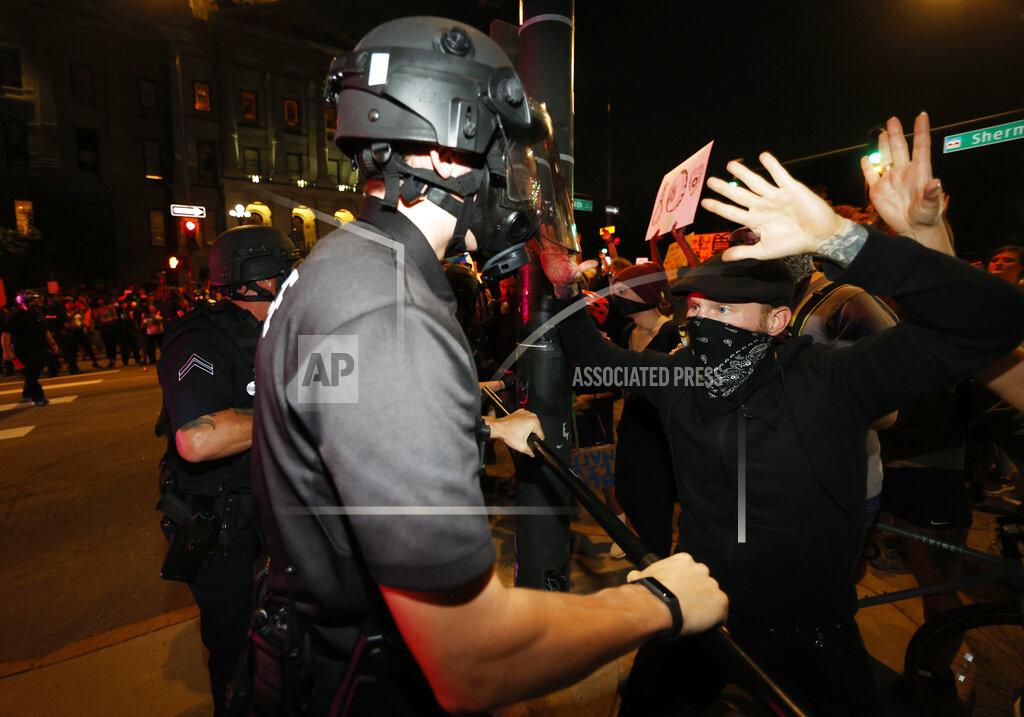 David Zalubowski A Denver police officer uses a baton to push back protester outside the State Capitol on Thursday, May 28, 2020, in Denver, during a demonstration over the Monday death of George Floyd in Minneapolis police custody. (AP Photo/David Zalubowski)