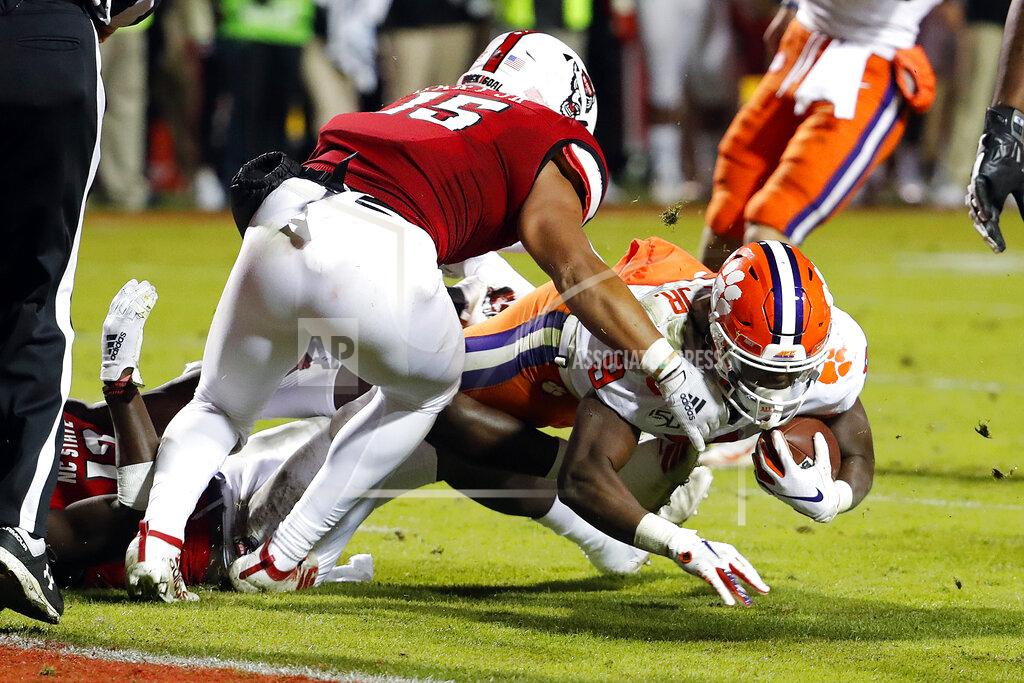 Karl B Deblaker Clemson's Travis Etienne (9) gets taken down short of the goal line by North Carolina State's C.J. Hart (15) during the first half of an NCAA college football game in Raleigh, N.C., Saturday, Nov. 9, 2019. (AP Photo/Karl B DeBlaker)