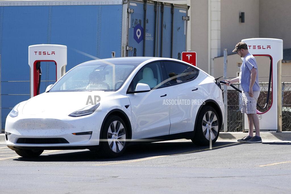 Orlin Wagner A Tesla owner charges his vehicle at a charging station in Topeka, Kan., Monday, April 5, 2021. The president and the auto industry maintain the nation is on the cusp of a gigantic shift to electric vehicles and away from liquid-fueled cars, but biofuels producers and some of their supporters in Congress aren’t buying it. They argue the U.S. should increase sales of ethanol and biodiesel, not abandon them. (AP Photo/Orlin Wagner)