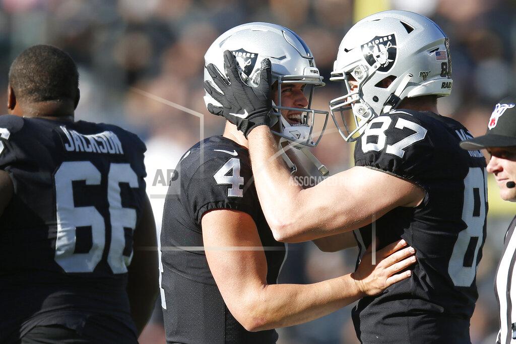 D. Ross Cameron Oakland Raiders quarterback Derek Carr (4) celebrates with tight end Foster Moreau (87) after a touchdown reception by wide receiver Rico Gafford during the first half of an NFL football game against the Tennessee Titans in Oakland, Calif., Sunday, Dec. 8, 2019. (AP Photo/D. Ross Cameron)