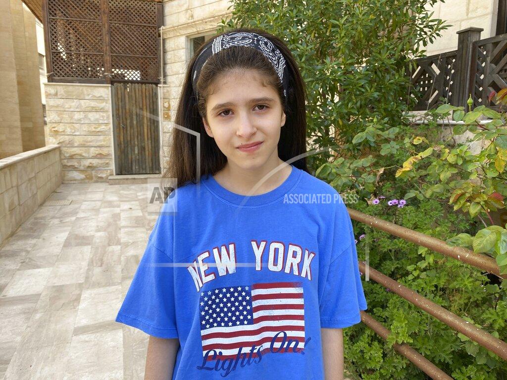 Omar Akour Baneen Ahmed stands for a portrait during the COVID-19 coronavirus lockdown in Amman, Jordan on April 15, 2020. Her family’s suffering in war-time Iraq has taught the 10-year old that outside events can turn life upside down in an instant. In the chaotic aftermath of the 2003 U.S.-led invasion of Iraq, an uncle was kidnapped, and a great-uncle was killed by armed militias, forcing her family to seek refuge in Jordan. (AP Photo/Omar Akour)