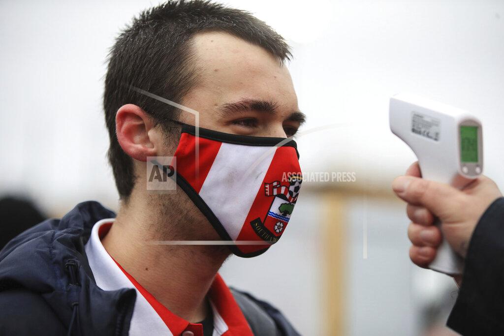 Uncredited Southampton fan gets temperature by a steward prior to enters the stadium to attend the English Premier League soccer match between Southampton and Sheffield United, at St. Mary's stadium in Southampton, England, Saturday, Dec. 13, 2020. (Adam Davy/Pool via AP)