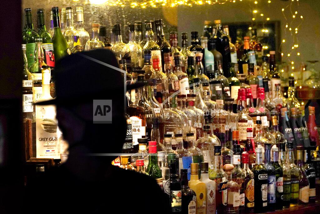 David J. Phillip Bottles of alcohol sit on the shelf behind the bar as Michael Neff, co-owner of the Cottonmouth Club, talks about the bar Tuesday, June 23, 2020, in Houston. Neff closed his downtown bar because of concerns within the industry as the number COVID-19 case continues to rise in Houston. (AP Photo/David J. Phillip)