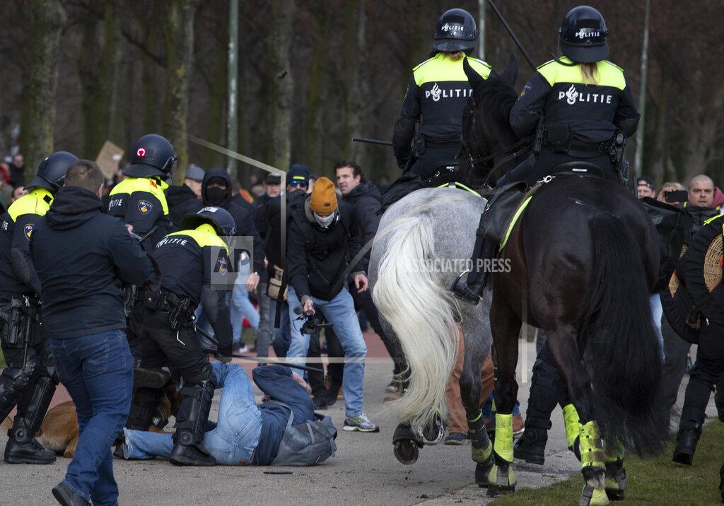 Peter Dejong Dutch riot police break up a demonstration of thousands who protested against government policies including the curfew, lockdown and coronavirus related restrictions in The Hague, Netherlands, Sunday, March 14, 2021. Thousands of people took part in the rally ahead of three days of voting starting Monday in a general election. (AP Photo/Peter Dejong)