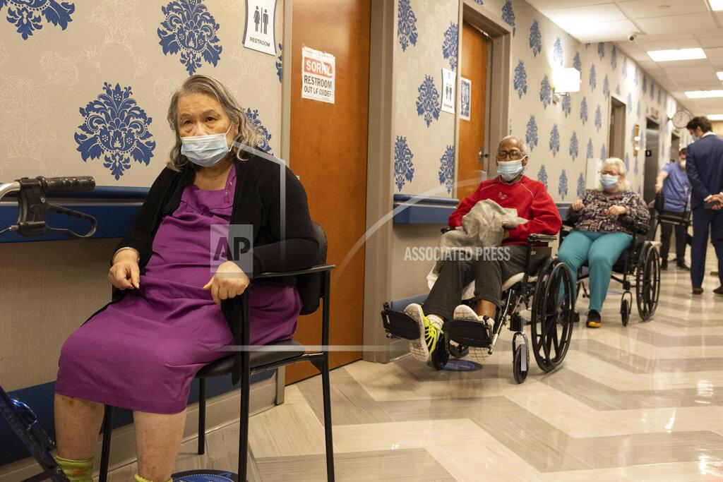 Yuki Iwamura FILE - Nursing home residents wait in line to receive a COVID-19 vaccine at Harlem Center for Nursing and Rehabilitation, a nursing home facility, on Friday, Jan. 15, 2021 in Harlem neighborhood of New York. A focus on the elderly at the start of the nation's vaccination campaign helped protect nursing homes that were ravaged at the height of the U.S. coronavirus outbreak, but they are far from in the clear. New outbreaks, often traced to infected staff members, are still occurring in long-term care centers across the country, causing continued havoc for visitation policies. (AP Photo/Yuki Iwamura)