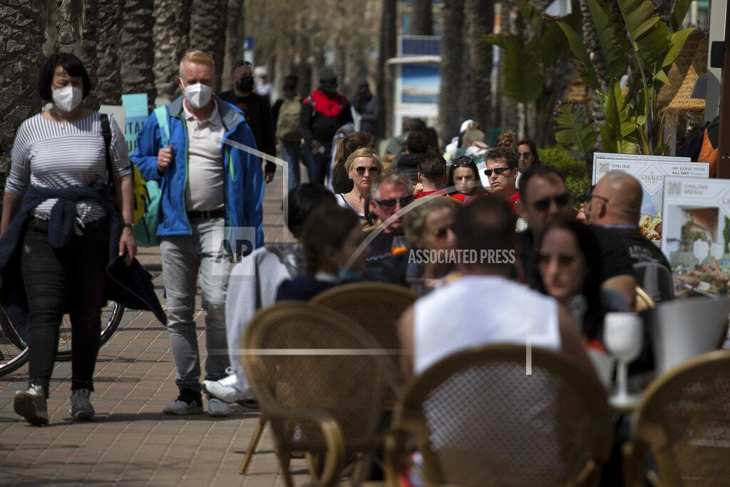 Francisco Ubilla Tourists sit on a terrace next to the sea at the Spanish Balearic Island of Mallorca, Spain, Saturday, March 27, 2021. Efforts in Spain to restart tourism activity is drawing a mixed picture due to a patchwork of national, regional and European rules on travel that is confusing both tourists and their hosts. (AP Photo/Francisco Ubilla)