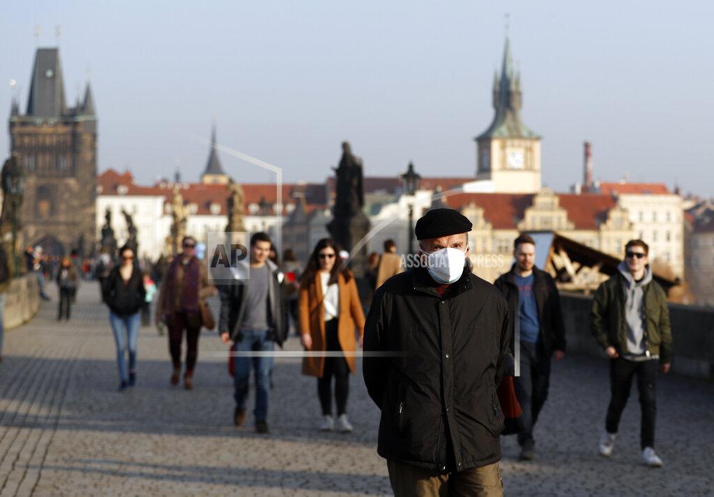 Petr David Josek A man wearing a face mask walks across the medieval Charles Bridge in Prague, Czech Republic, Thursday, Feb. 25, 2021. The Czech government is barring the citizens and residents from travelling to the countries hit by highly contagious coronavirus variants and is tightening the rules for face coverings. Starting on Thursday, the Czechs are required to wear better masks in places where large numbers gather, including stores, hospitals and public transportation. (AP Photo/Petr David Josek)