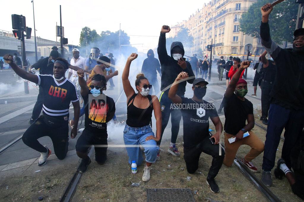 Michel Euler Protesters react during a demonstration Tuesday, June 2, 2020 in Paris. Paris riot officers fired tear gas as scattered protesters threw projectiles and set fires at an unauthorized demonstration against police violence and racial injustice. Several thousand people rallied peacefully for two hours around the main Paris courthouse in homage to George Floyd and to Adama Traore, a French black man who died in police custody. (AP Photo/Michel Euler)