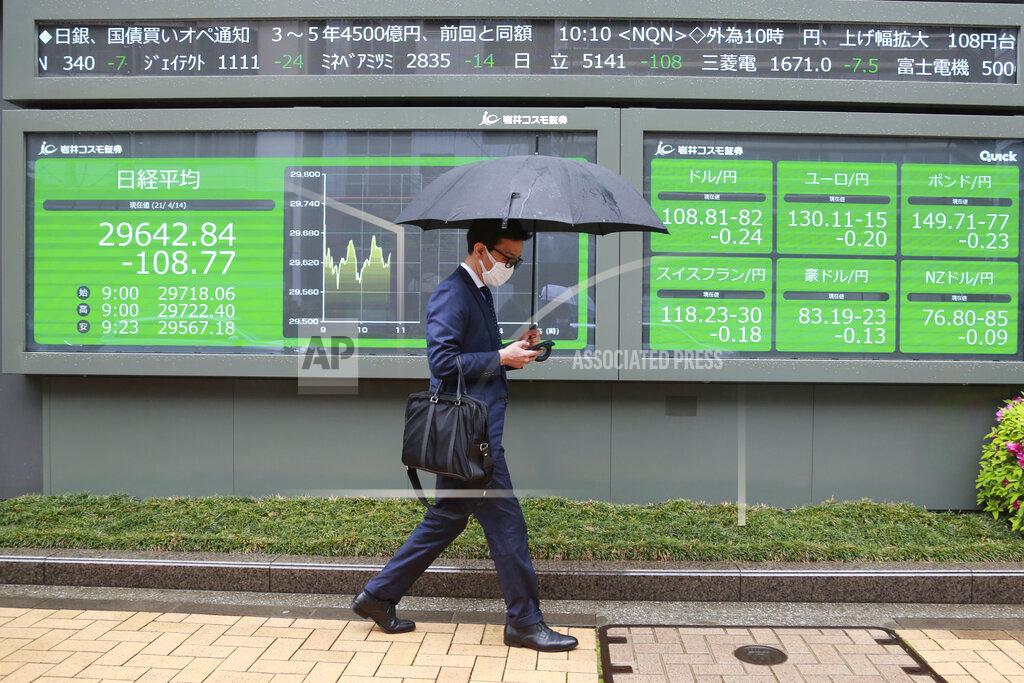 Koji Sasahara A man walks by an electronic stock board of a securities firm in Tokyo, Wednesday, April 14, 2021. Asian stock markets rose Wednesday after Wall Street hit a high following an uptick in U.S. inflation and an order by regulators to suspend use of Johnson & Johnson's coronavirus vaccine. (AP Photo/Koji Sasahara)