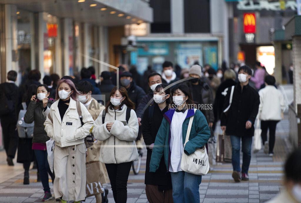 Hiro Komae People wearing face masks walk by a train station during a coronavirus state of emergency in Tokyo on Thursday, Jan. 14, 2021. (AP Photo/Hiro Komae)