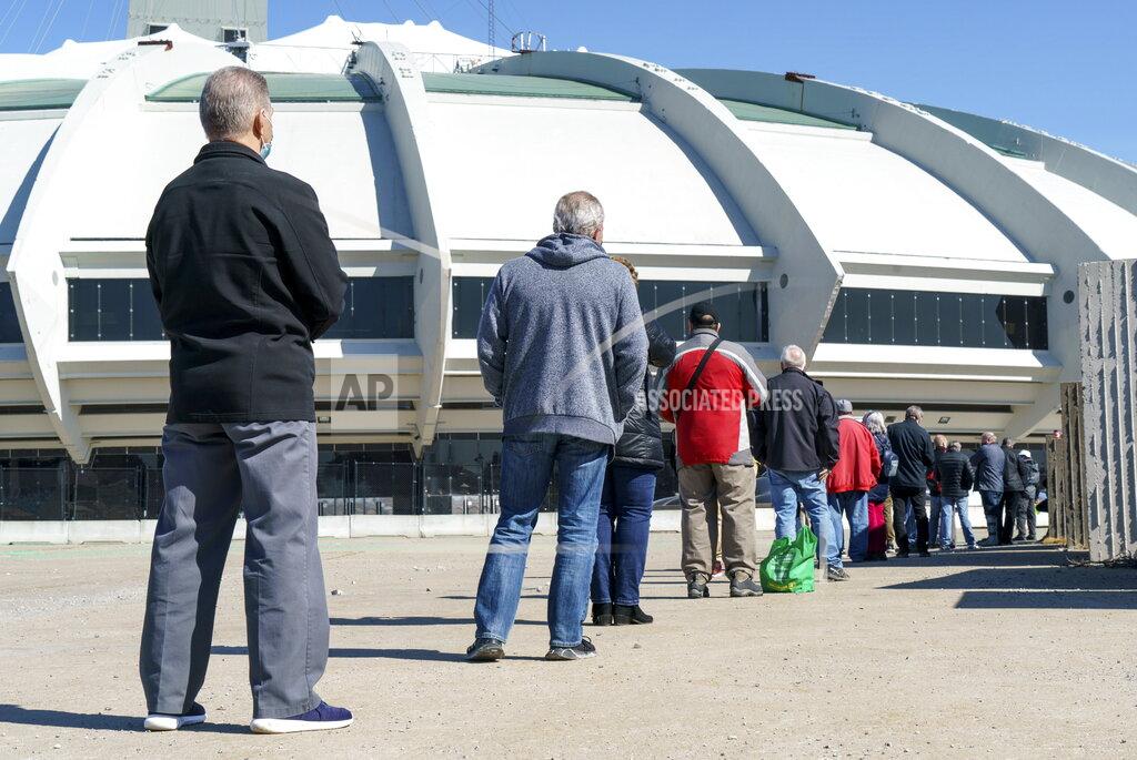 Paul Chiasson People wait in line at a COVID-19 vaccination clinic to receive the AstraZeneca vaccine at Olympic Stadium in Montreal, on Thursday, April 8, 2021. Quebecers 55 and over can now get the AstraZeneca vaccine at walk-in clinics across the province. (Paul Chiasson/The Canadian Press via AP)