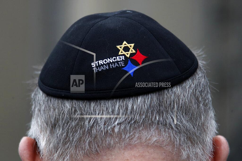Gene J. Puskar FILE - In this Sunday, Oct. 27, 2019 file photo, a man wearing a "Stronger Than Hate" yarmulke stands outside the Tree of Life synagogue in Pittsburgh on the first anniversary of the shooting at the synagogue, that killed 11 worshippers. On Tuesday, Oct. 27, 2020, as they again mourn those killed two years earlier, they’ll also celebrate the resilience that has enabled them to persevere. (AP Photo/Gene J. Puskar)
