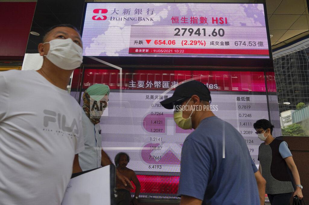 Vincent Yu People walk past a bank's electronic board showing the Hong Kong share index at Hong Kong Stock Exchange Tuesday, May 11, 2021. Shares dropped Tuesday in Asia after selling of several Big Tech companies pulled U.S. benchmarks lower. (AP Photo/Vincent Yu)