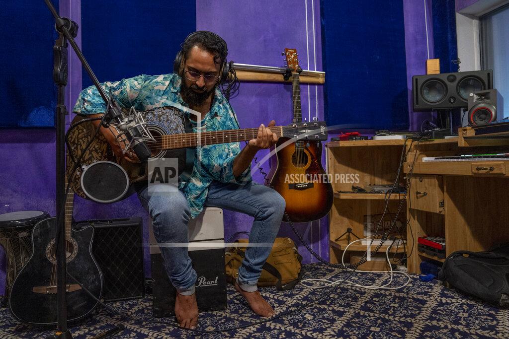 Dar Yasin Zeeshan Nabi, a Kashmiri Musician and singer records music inside his studio on the outskirts of Srinagar, Indian controlled Kashmir, June 13, 2022. Musicians and artists in Kashmir are ordinary in life, each clutching onto the lived experiences of growing up in one of the world's most militarized zones that has known little but conflict for decades. But together, they embody a new form of music, a blend of progressive rock and hip hop that is an assertive expression of the region's political and cultural aspirations. (AP Photo/Dar Yasin)