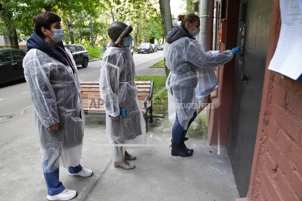 Pavel Golovkin Members of an election commission, wearing gear to protect against coronavirus, enter a residential building as they come to visit a voter who wanted to vote at home during a parliamentary elections in Moscow, Russia, Saturday, Sept. 18, 2021. Sunday, Sept.19 will be the last of three days voting for a new parliament, but there seems to be no expectation that United Russia, the party devoted to President Vladimir Putin, will lose its dominance in the State Duma. (AP Photo/Pavel Golovkin)