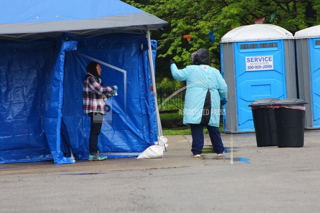 Noreen Nasir In this May 14, 2020 photo, a woman gets tested at a new testing site in the Little Village neighborhood of Chicago. Chicago’s Little Village neighborhood is known as the heart of Mexican culture in the city. It’s also located in the zip code area with one of the highest rates of positive coronavirus cases in the city. Across the country, states reporting racial data indicate similar trends, with overwhelmingly high rates of infection within the Latino population. (AP Photo/Noreen Nasir)