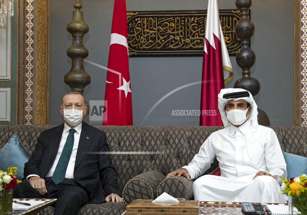 Uncredited In this photo released by the Qatar Amiri Diwan, Turkish President Recep Tayyip Erdogan, left, poses with the Emir of Qatar Sheikh Tamim bin Hamad Al Thani, in Doha, Qatar, Wednesday, Oct. 7, 2020. (Qatar Amiri Diwan via AP)