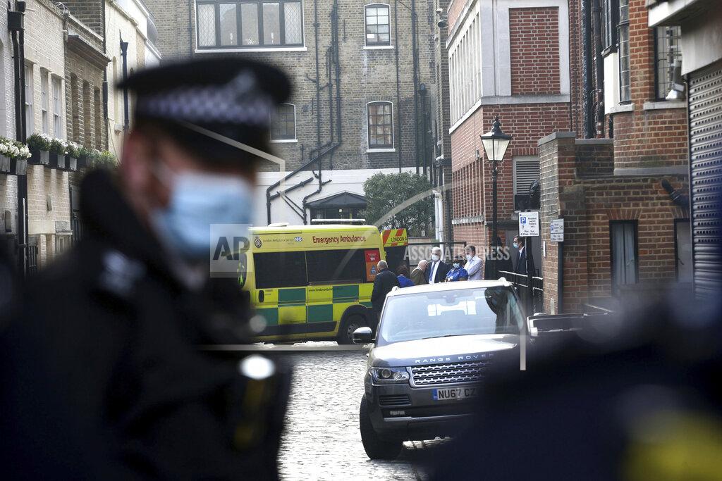 Dominic Lipinski Members of hospital staff, security and police officers attend as an ambulance moves outside the rear of the King Edward VII Hospital in London where Prince Philip is being treated Monday March 1, 2021. (Dominic Lipinski/PA via AP)