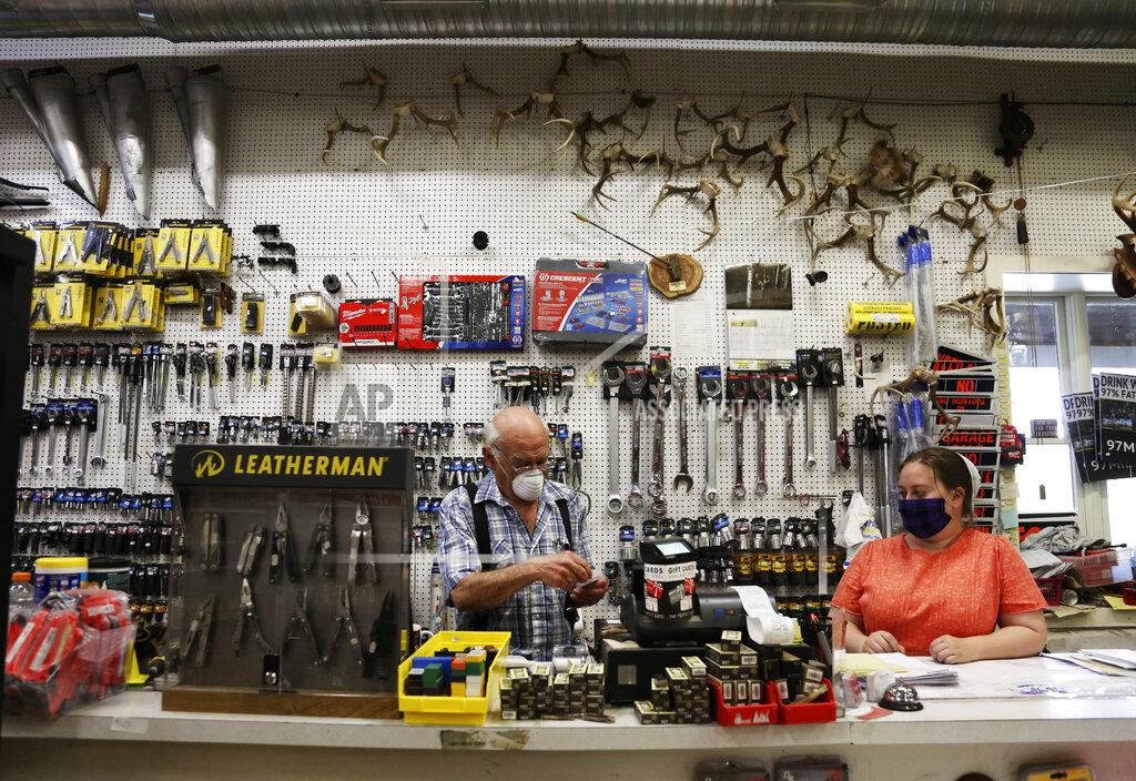 Jessie Wardarski In this Monday, May 4, 2020, photo, Aaron Hurst, 67, left, wears a mask as he runs his AAA Farm Supply business in Terre Hill, Pa. (AP Photo/Jessie Wardarski)