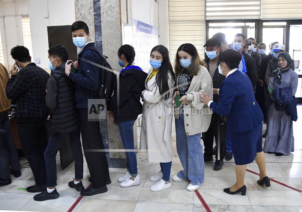 Uncredited People stand in a line to a polling station during the presidential election in Tashkent, Uzbekistan, Sunday, Oct. 24, 2021. Uzbeks voted Sunday in a presidential election that the incumbent is expected to win in a landslide against weak competition. Although Shavkat Mirziyoyev has relaxed many of the policies of his dictatorial predecessor, he has made little effort at political reform. He took office in 2016 upon the death of Islam Karimov and faces four relatively low-visibility candidates who did not even show up for televised debates. (AP Photo)