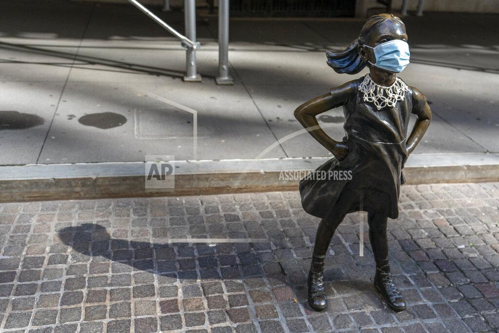 Mary Altaffer A face mask and a Ruth Bader Ginsberg collar is placed on The Fearless Girl statue during the Women's March outside the New York Stock Exchange, Saturday, Oct. 17, 2020, in New York. Dozens of Women's March rallies were planned from New York to San Francisco to signal opposition to President Donald Trump and his policies, including the push to fill the seat of late Supreme Court Justice Ruth Bader Ginsburg before Election Day. (AP Photo/Mary Altaffer)
