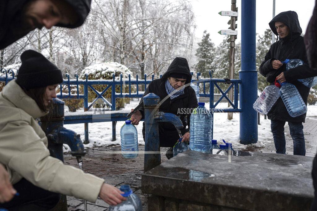 Evgeniy Maloletka People collect water, in Kyiv, Ukraine, Thursday, Nov. 24, 2022. Residents of Ukraine's bombed but undaunted capital clutched empty bottles in search of water and crowded into cafés for power and warmth Thursday, switching defiantly into survival mode after new Russian missile strikes a day earlier plunged the city and much of the country into the dark.
(AP Photo/Evgeniy Maloletka)