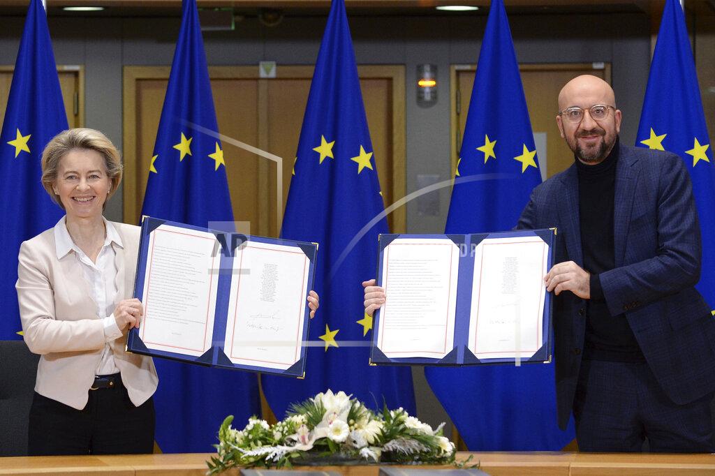 FILE - In this Wednesday, Dec. 30, 2020 file photo, European Commission President Ursula von der Leyen, left, and European Council President Charles Michel show the signed EU-UK Trade and Cooperation Agreement at the European Council headquarters in Brussels. A last-minute trade deal with the United Kingdom coupled with the rollout of COVID-19 vaccines in the final days of the year produced a sense of success for the 27-nation bloc and brought glimmers of hope to the EU's 450 million residents. (Johanna Geron/Pool Photo via AP, File)