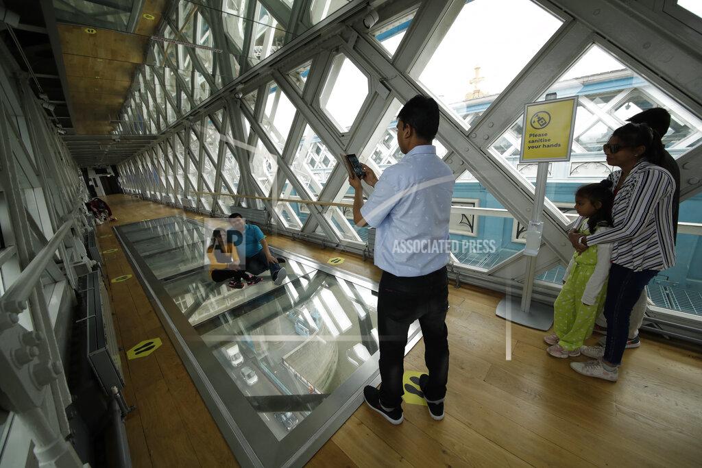 Matt Dunham Visitors pose for photographs on the glass walkway at the Tower Bridge Visitor Attraction, in London, on the first day it was allowed to reopen as the British government relaxes its third coronavirus lockdown restrictions, Monday, May 17, 2021. (AP Photo/Matt Dunham)