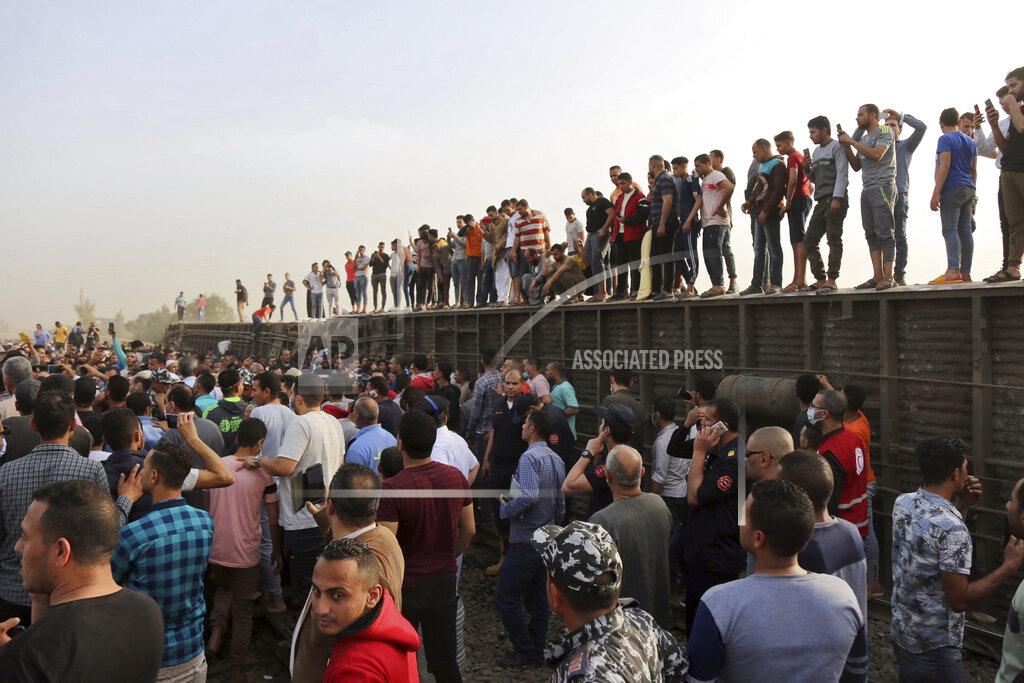 Fadel Dawood People gather at the site where a passenger train derailed injuring at least 100 people, in Banha, Qalyubia province, Egypt, Sunday, April 18, 2021. At least eight train wagons ran off the railway, the provincial governor's office said in a statement. (AP Photo/Fadel Dawood)