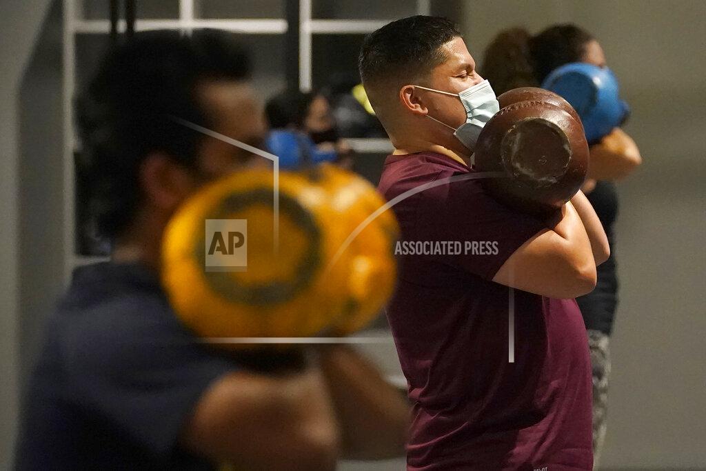 Jeff Chiu FILE - In this Nov. 24, 2020, file photo, Juan Avellan, center, and others wear masks while working out in an indoor class at a Hit Fit SF gym amid the coronavirus outbreak in San Francisco. Health officials in San Francisco and six other Bay Area counties announced Monday, Aug. 2, 2021 that they are reinstating a mask mandate for all indoor setting as COVID-19 infections surge because of the highly contagious delta variant. (AP Photo/Jeff Chiu, File)