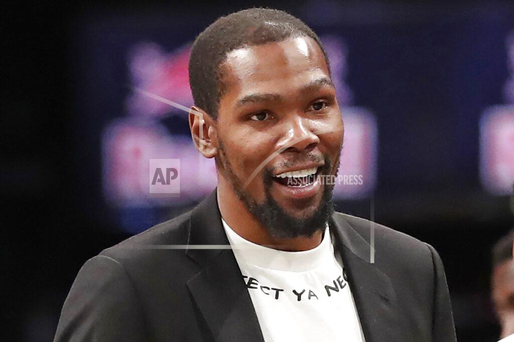 FILE - In this Dec. 26, 2019, file photo, injured Brooklyn Nets player Kevin Durant smiles as he greets teammates returning to the bench during a timeout in the second half of an NBA basketball game against the New York Knicks, in New York. Brooklyn Nets forward Kevin Durant has joined the ownership group of Major League Soccer's Philadelphia Union. Durant, a 10-time NBA All-Star, has a 5% ownership stake, with an option for 5% more in the near future, the Union announced Monday, June 15, 2020. (AP Photo/Kathy Willens, File)
