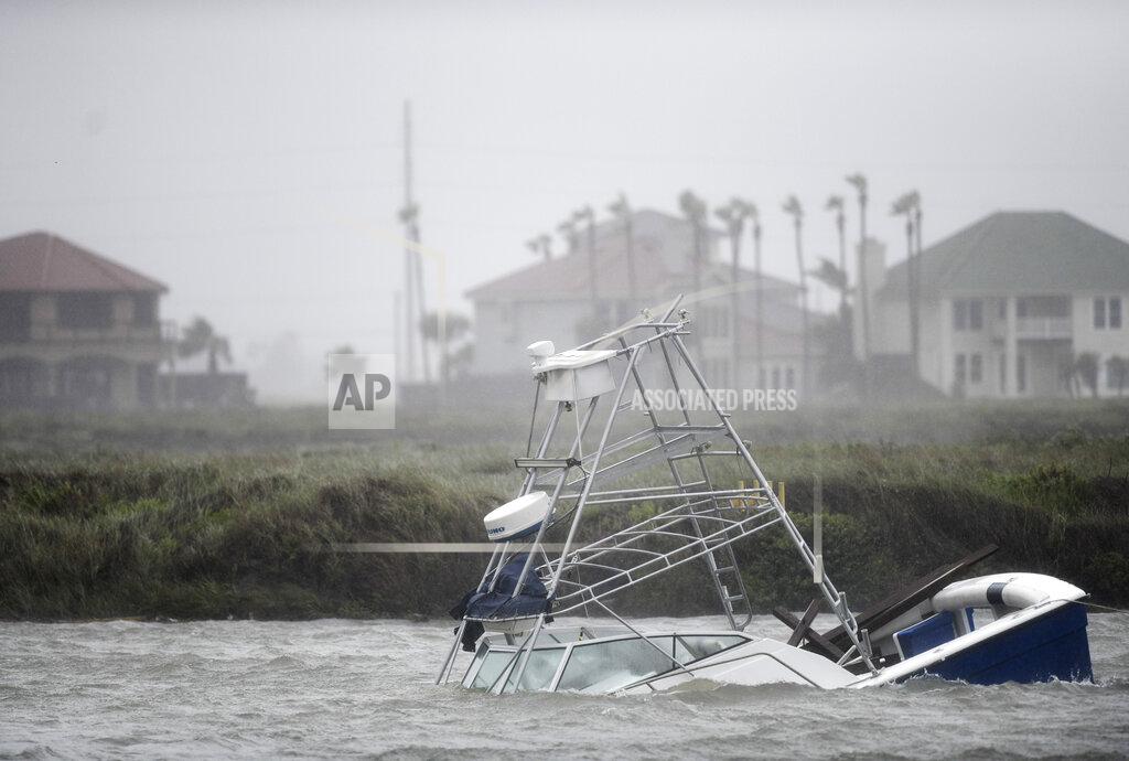Annie Rice A boat sinks in the Packery Channel during Hurricane Hanna, Saturday, July 25, 2020, in North Padre Island, Texas. The Category 1 storm continued to strengthen before reaching Padre Island at 5 p.m. Saturday. (Annie Rice/Corpus Christi Caller-Times via AP)