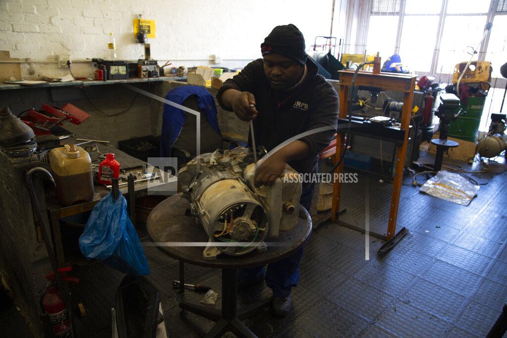 Denis Farrell A man services a power generator at a store in Johannesburg, Thursday, June 30, 2022. South Africans are struggling in the dark to cope with increased power cuts that have hit households and businesses across the country. The rolling power cuts have been experienced for years but this week the country’s state-owned power utility Eskom extended them so that some residents and businesses have gone without power for more than 9 hours a day. (AP Photo/Denis Farrell)