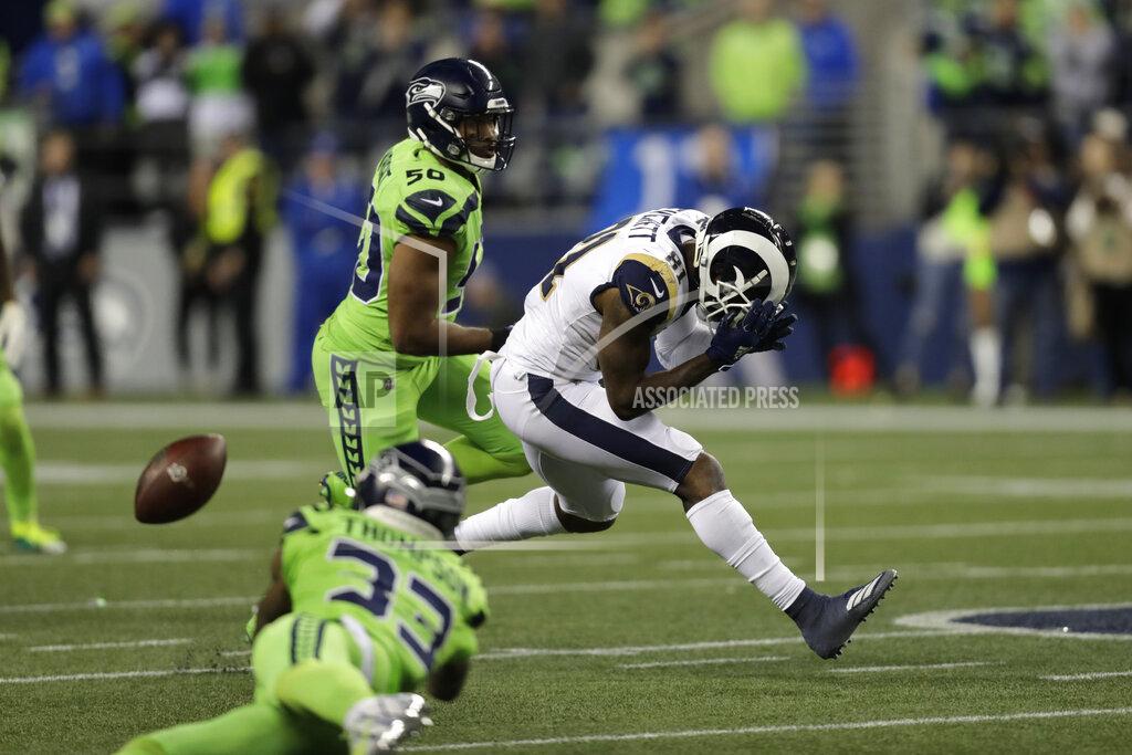 Stephen Brashear Los Angeles Rams tight end Gerald Everett, right, reacts after missing a pass that was intercepted by Seattle Seahawks free safety Tedric Thompson, front left, as as Seahawks' K.J. Wright, back left, watches during the second half of an NFL football game Thursday, Oct. 3, 2019, in Seattle. (AP Photo/Stephen Brashear)