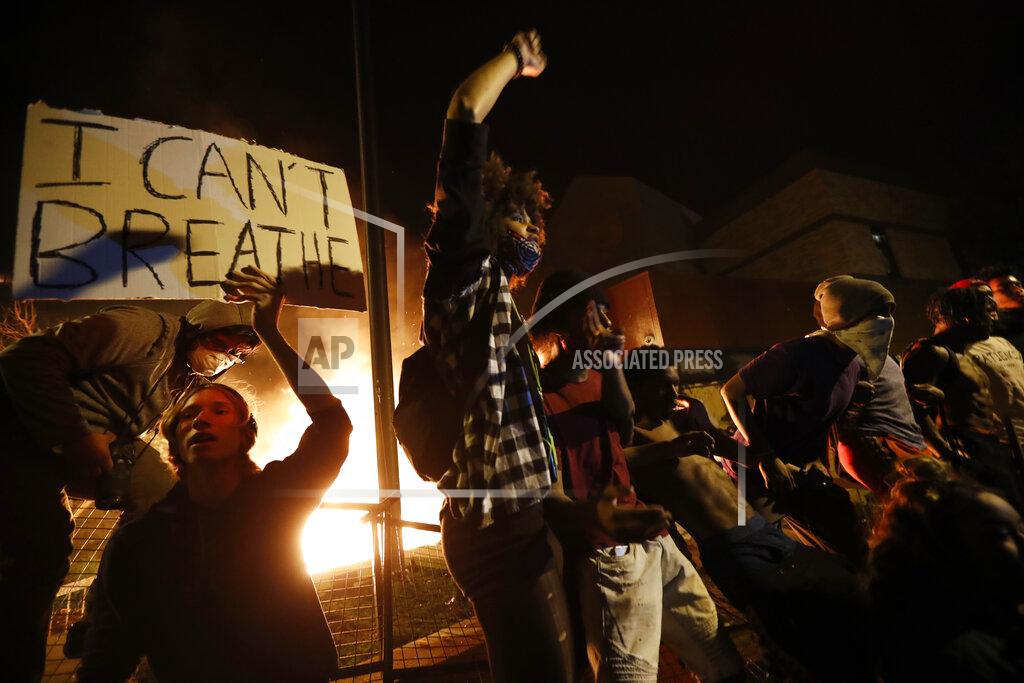 John Minchillo Protesters gather outside the burning Minneapolis police 3rd Precinct building Thursday, May 28, 2020, in Minneapolis. Potests over the death of George Floyd, a black man who died in police custody Monday, broke out in Minneapolis for a third straight night. (AP Photo/John Minchillo)