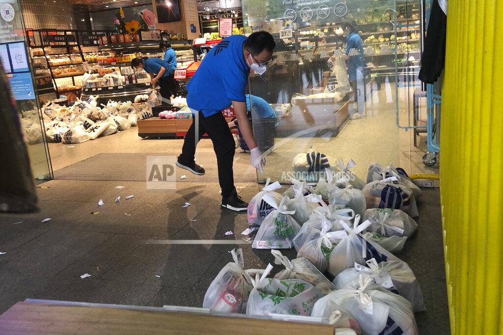 Chen Si A supermarket employee prepares bags of groceries for delivery in Shanghai, China, Monday, May 23, 2022. Shanghai reported 480,000 people were still confined to their homes due to COVID-19 precautions, while 1.59 million were permitted to move around their neighborhoods and 21.2 million were under lighter restrictions. (AP Photo/Chen Si)