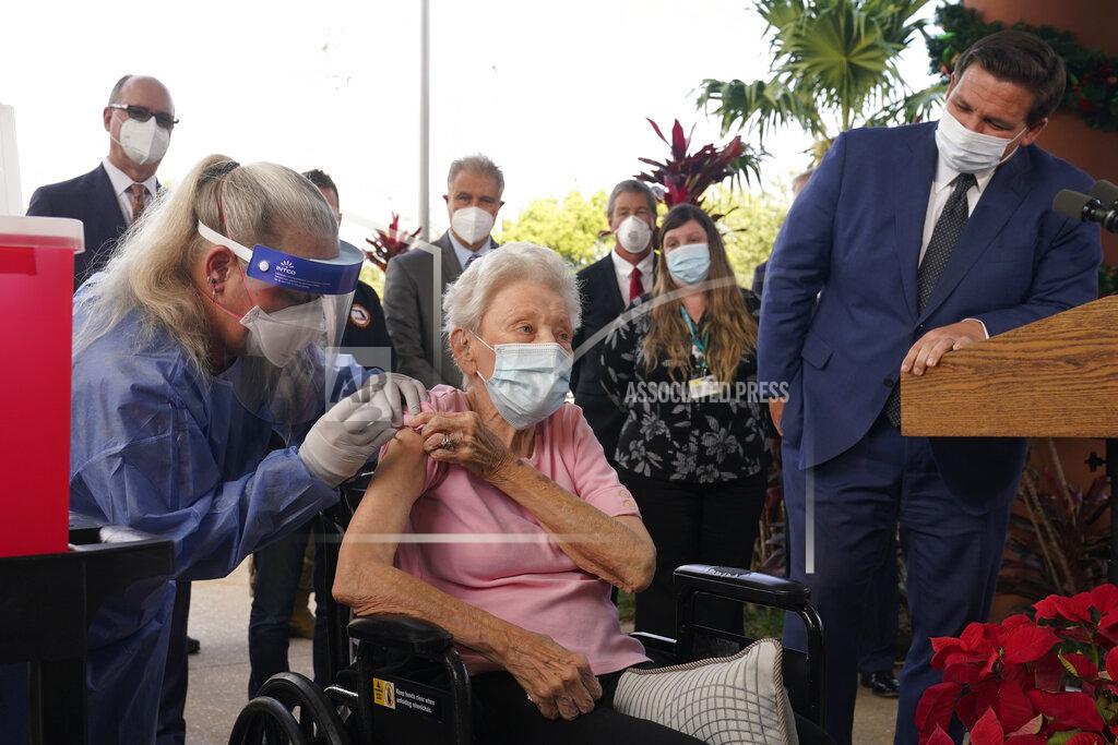 Marta Lavandier FILE- In this Dec. 16, 2020, file photo, Florida Gov. Ron DeSantis watches as nurse Christine Philips, left, administered the Pfizer vaccine to resident Vera Leip, 88, at John Knox Village, in Pompano Beach, Fla. Nursing home residents and health care workers in Florida began receiving the Pfizer vaccine. (AP Photo/Marta Lavandier, File)