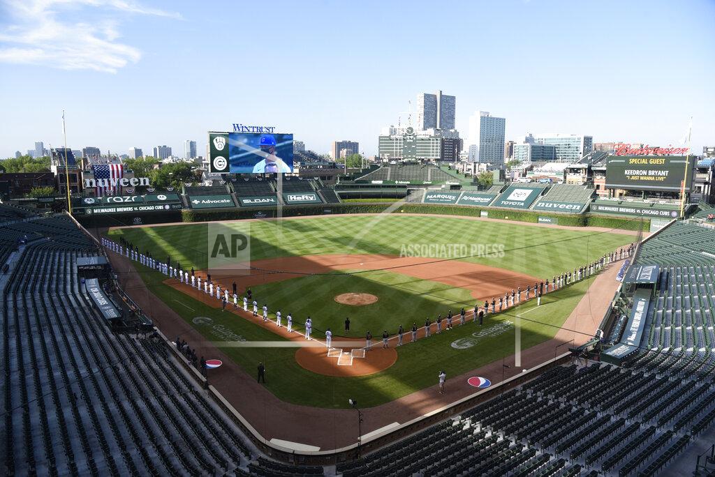 David Banks The Chicago Cubs and the Milwaukee Brewers stand for the national anthem before an opening day baseball game Friday, July, 24, 2020, in Chicago. (AP Photo/David Banks)