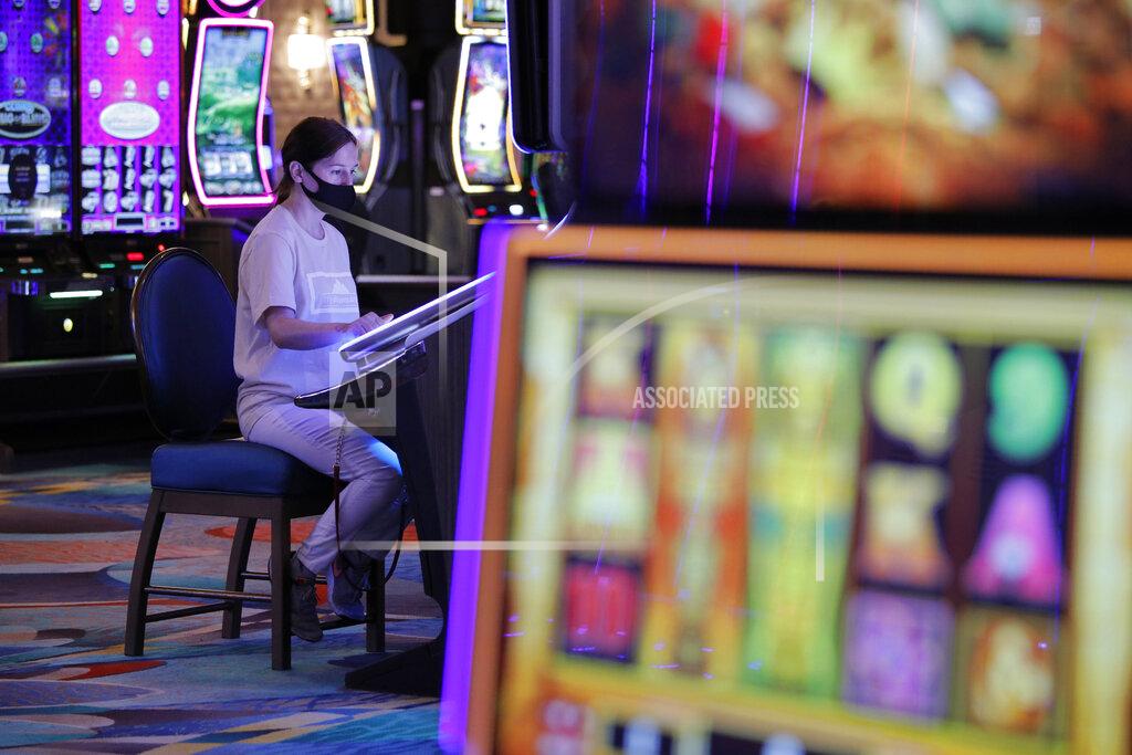 John Locher A woman plays an electronic slot machine at at the reopening of the Bellagio hotel and casino Thursday, June 4, 2020, in Las Vegas. Casinos in Nevada were allowed to reopen on Thursday for the first time after temporary closures as a precaution against the coronavirus. (AP Photo/John Locher)