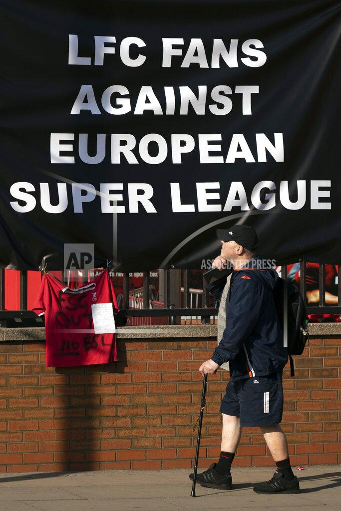 Jon Super A member of the public passes a banner outside Liverpool's Anfield Stadium protesting the formation of the European Super League, Liverpool, England, Monday, April 19, 2021. Players at the 12 clubs setting up their own Super League could be banned from this year's European Championship and next year's World Cup, UEFA President Aleksander Ceferin said Monday.