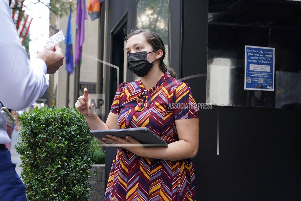 Seth Wenig FILE - In this Sept. 13, 2021, file photo, Maitre d' Susanne McDonald checks guests' proof of vaccination at a restaurant in midtown Manhattan in New York. COVID-19 deaths and cases in the U.S. have climbed back to where they were over the winter, wiping out months of progress and potentially bolstering President Joe Biden’s case for sweeping new vaccination requirements. (AP Photo/Seth Wenig, File)