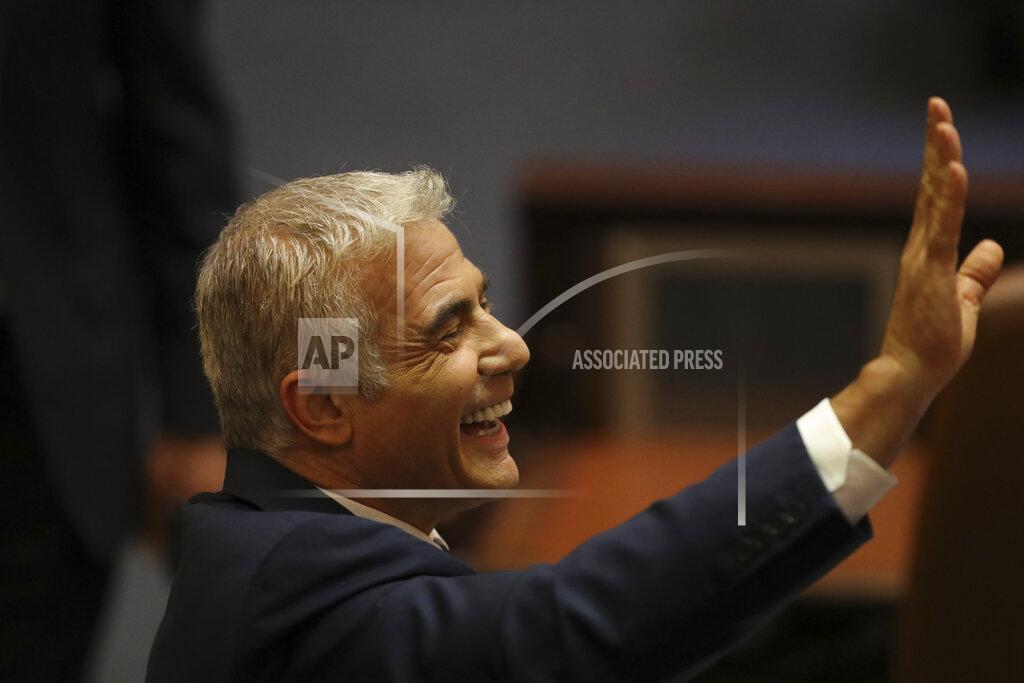 Ariel Schalit Israeli politician Yair Lapid of the Yesh Atid party sends greetings during a Knesset session in Jerusalem Sunday, June 13, 2021. Bennett is expected later Sunday to be sworn in as the country's new prime minister, ending Prime Minister Benjamin Netanyahu's 12-year rule. (AP Photo/Ariel Schali22