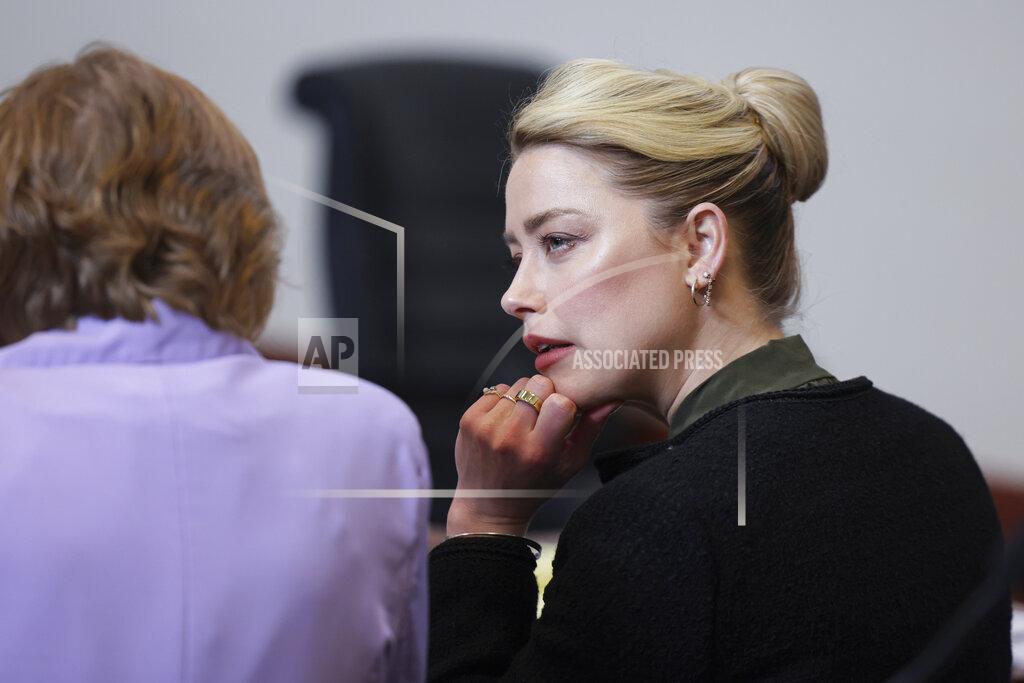 Evelyn Hockstein Actor Amber Heard speaks with a legal team member at the Fairfax County Circuit Courthouse in Fairfax, Va., Wednesday, May 25, 2022. Actor Johnny Depp sued his ex-wife Amber Heard for libel in Fairfax County Circuit Court after she wrote an op-ed piece in The Washington Post in 2018 referring to herself as a "public figure representing domestic abuse." (Evelyn Hockstein/Pool photo via AP)