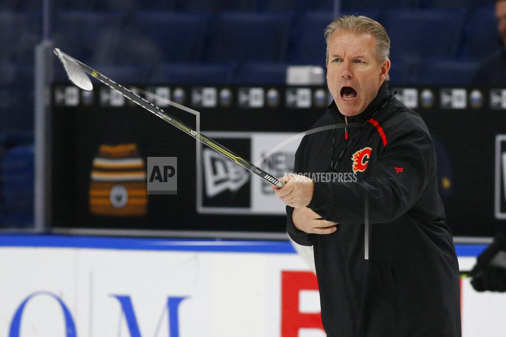 Jeffrey T. Barnes Calgary Flames associate coach Geoff Ward gives instruction during an NHL hockey practice Tuesday, Nov. 26, 2019, in Buffalo, N.Y. Flames general manager Brad Treliving says coach Bill Peters remains on the staff but wasn’t certain whether he’d be behind the bench for the next game. The team and the NHL are both investigating an allegation the Peters directed racial slurs at a player 10 years ago when the two were in the minors. Akim Aliu, a Nigerian-born player, says Peters “dropped the N bomb several times” in a dressing room during his rookie year. (AP Photo/Jeffrey T. Barnes)